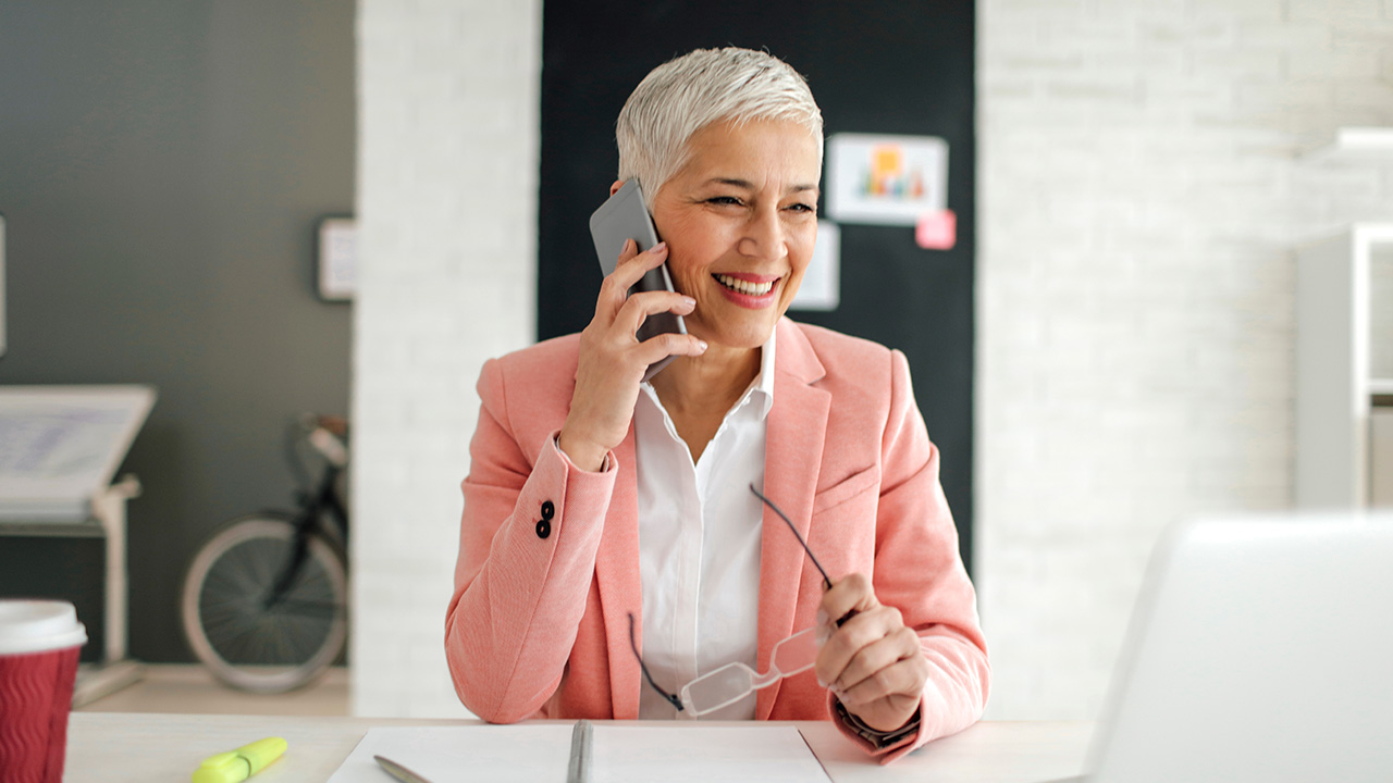 Woman calling through her phone wearing pink coat